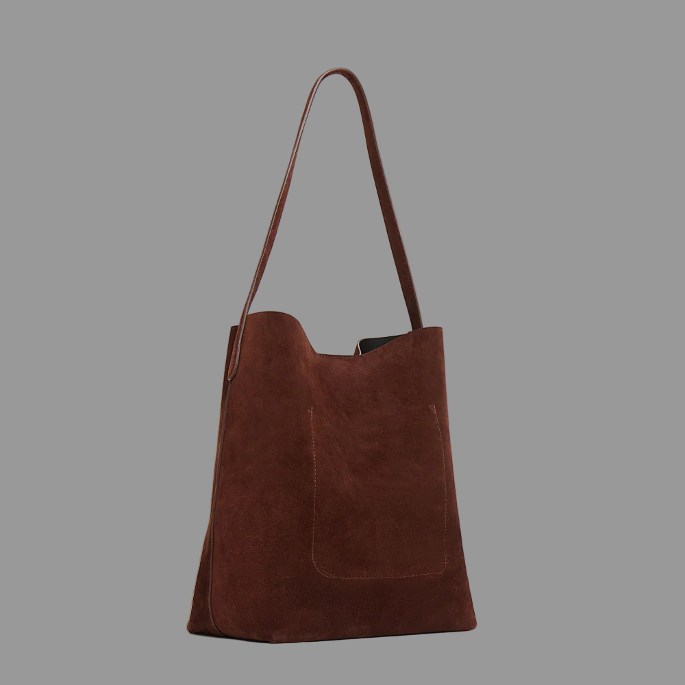 Chocolate suede leather bag on a grey background
