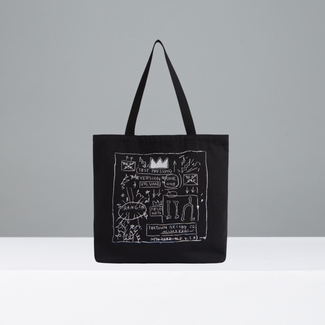 Black tote bag with white graphic design on a gray background