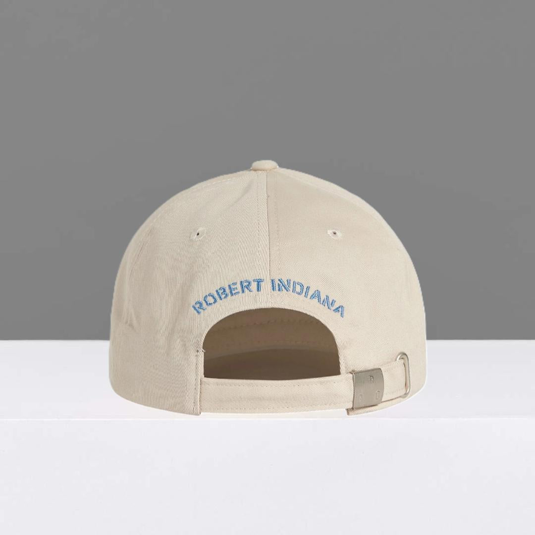 Back of stone colored cap with 'Robert Indiana' embroidered in blue on a gray background