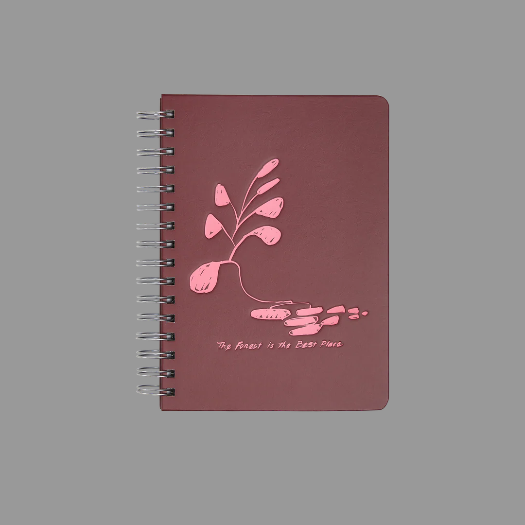 Maroon notebook with pink floral design on a gray background