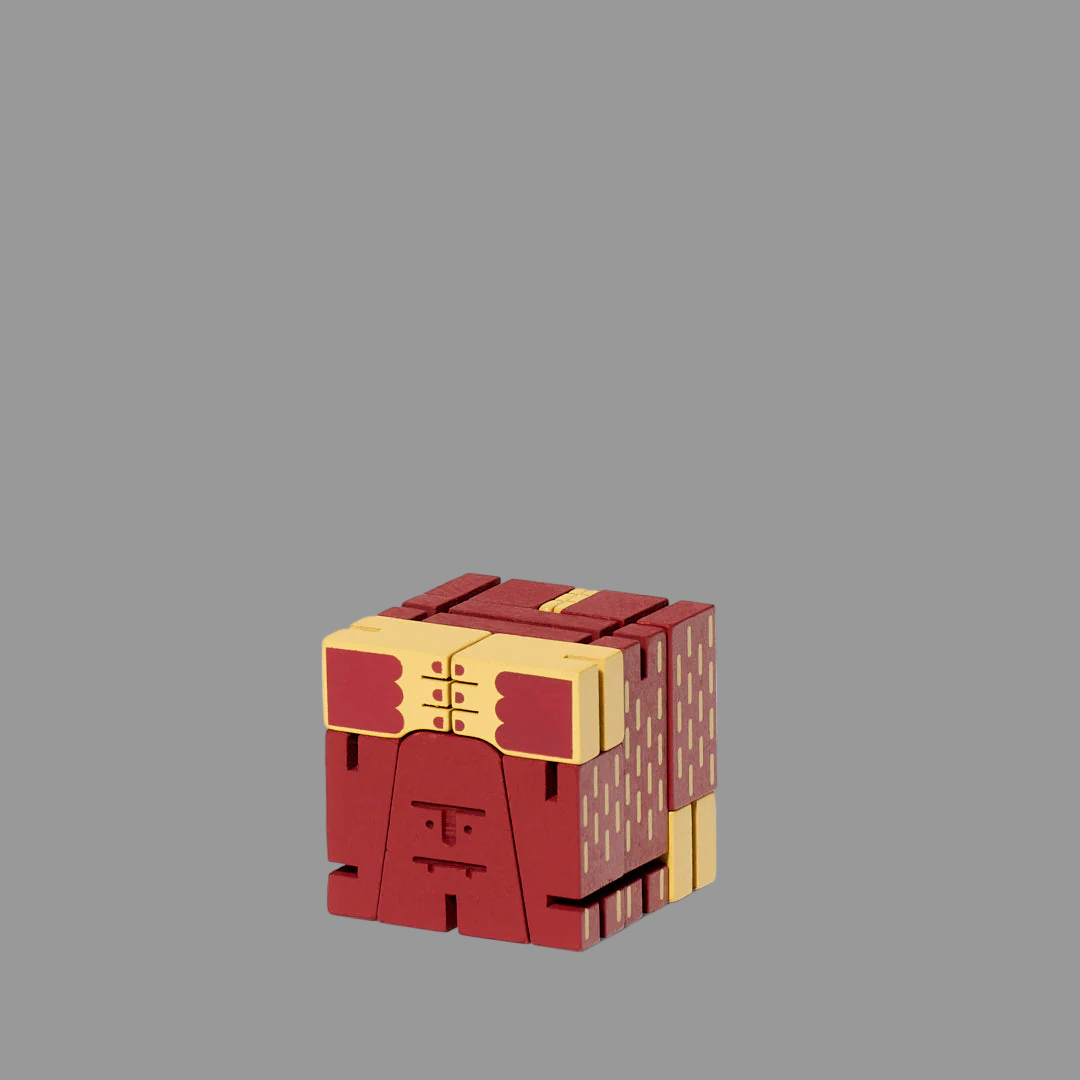 Red and yellow cube-shaped toy on a grey background