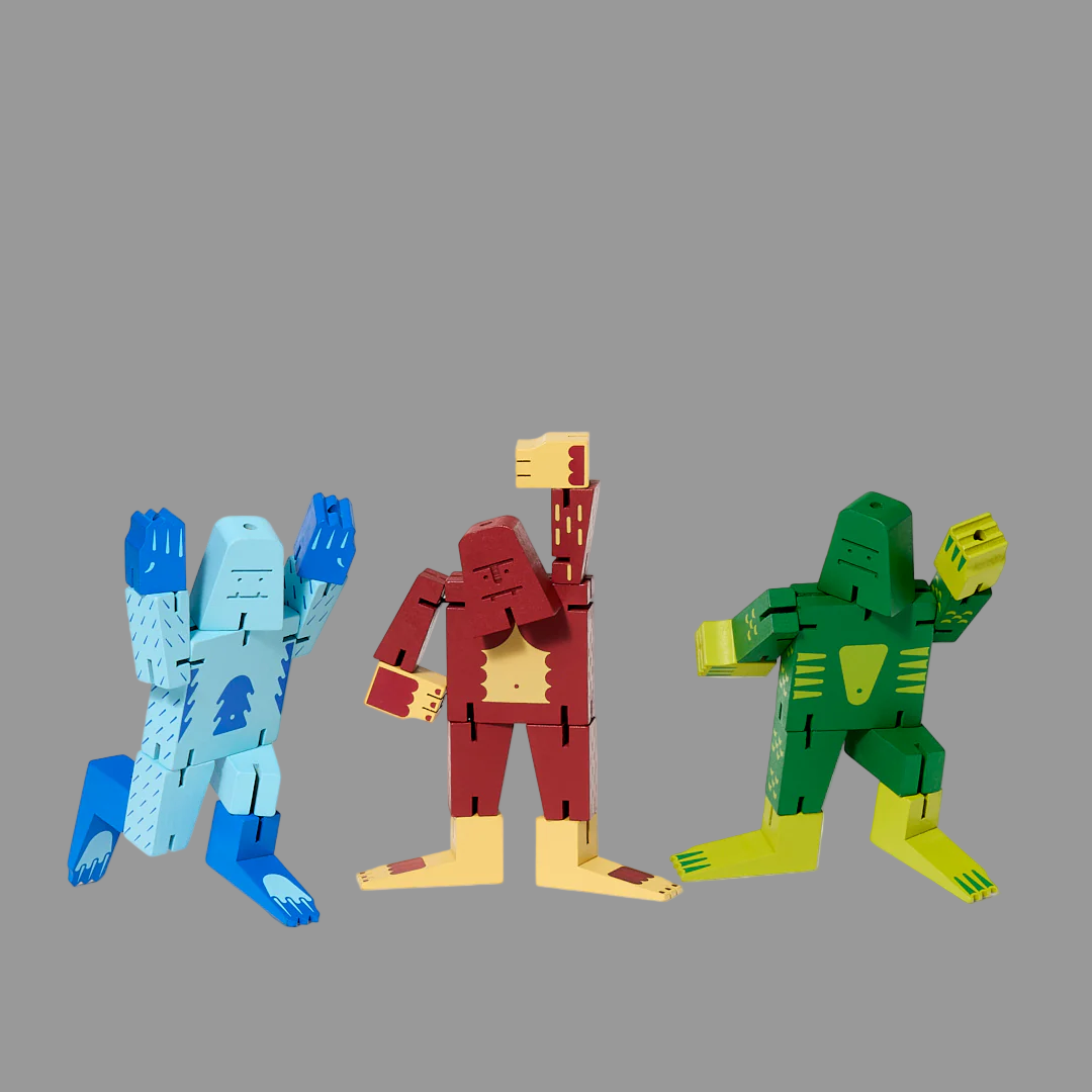 Three colorful wooden toy figures on a grey background