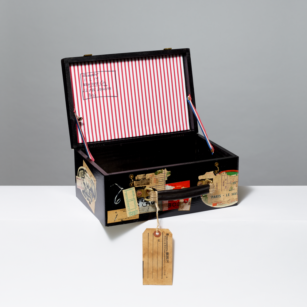 Decorative black box with striped interior and vintage-style tags on a gray background
