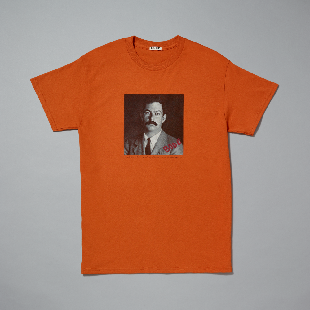 Orange t-shirt with a printed design on a gray background
