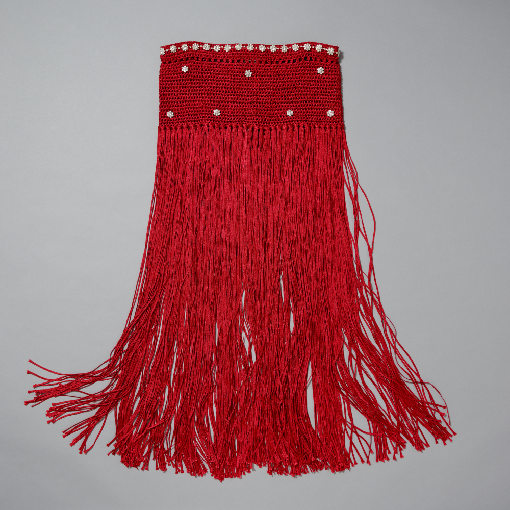 Red fringe skirt with rhinestone florets on a gray background
