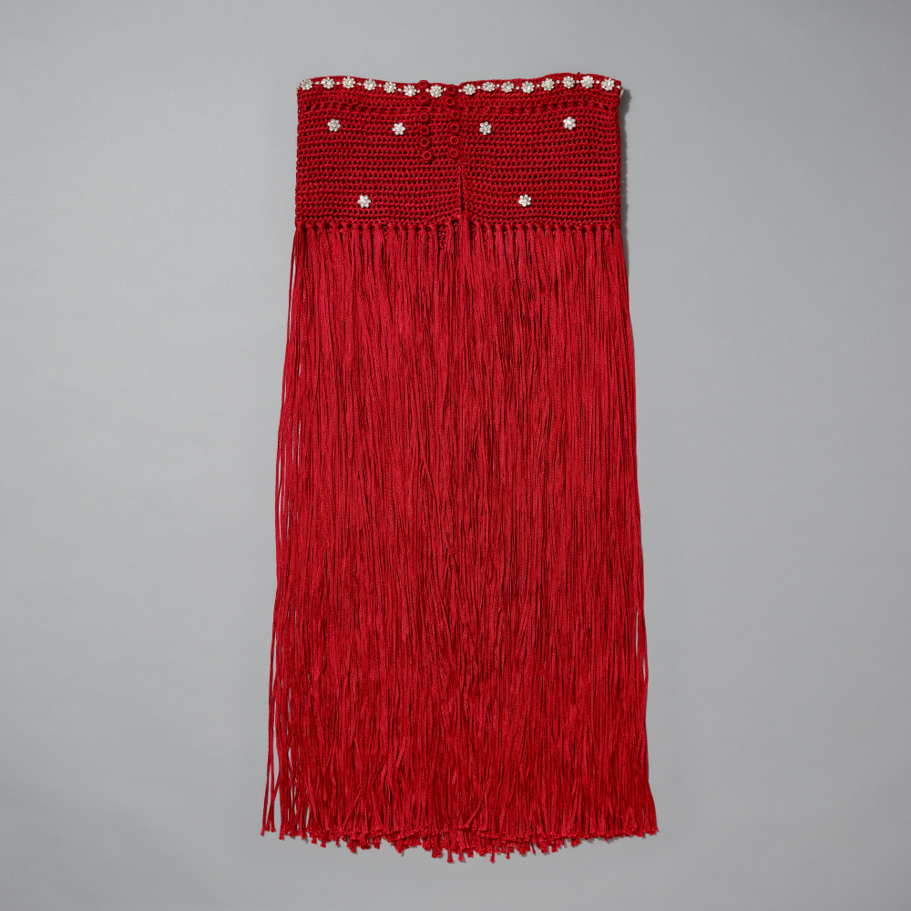 Red fringe skirt with rhinestone florets on a gray background