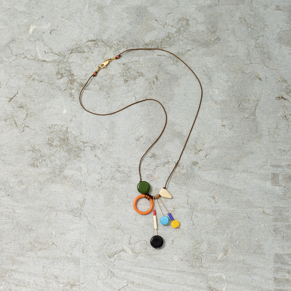 Necklace with colorful pendants on a textured gray surface