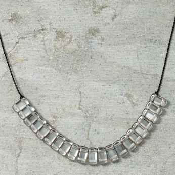 Silver necklace on a textured gray surface
