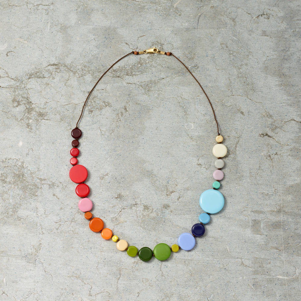 Colorful necklace with multicolored beads on a textured gray surface