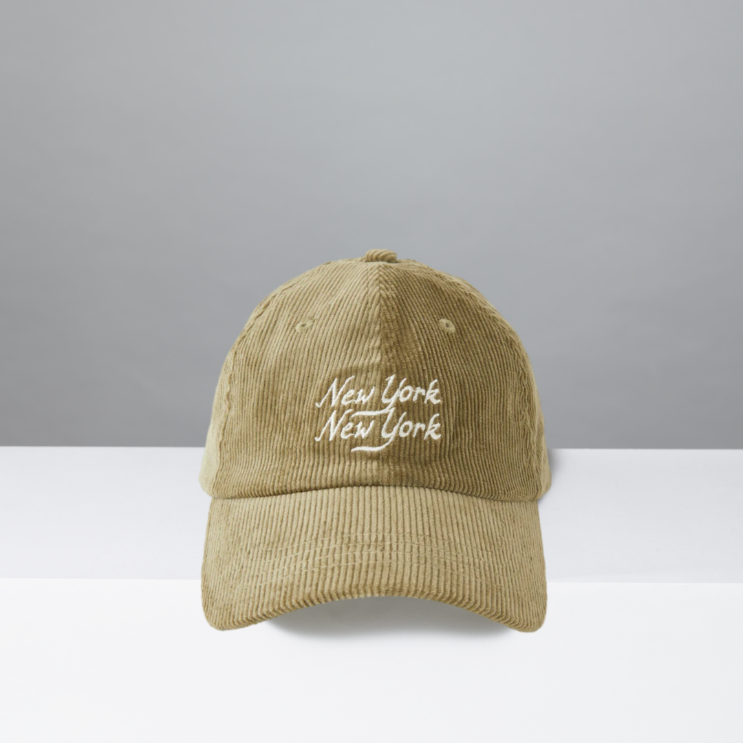 Olive corduroy cap with 'New York New York' text on a gray background