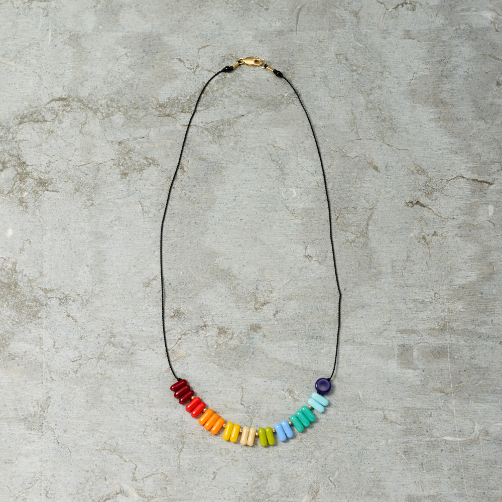 Necklace with colorful beads on a gray textured background