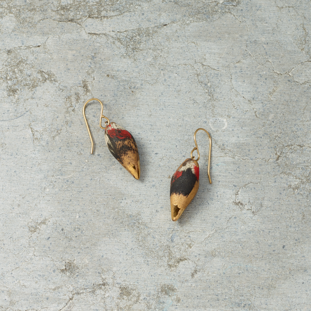 Pair of earrings with a natural shell design on a textured gray surface