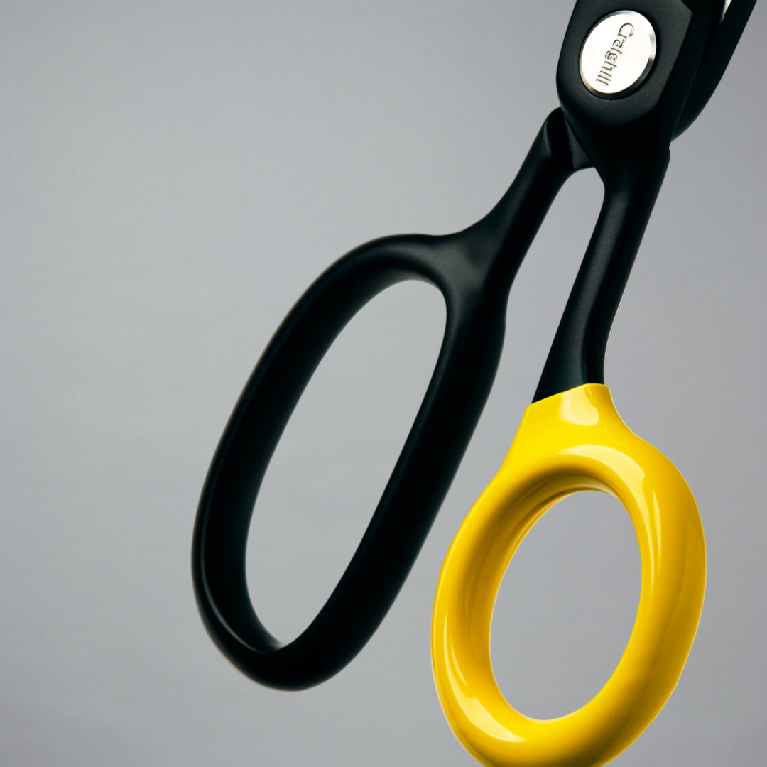 Black and yellow scissors on a gray background