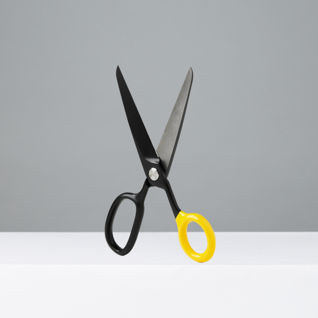 Black and yellow scissors on a gray background