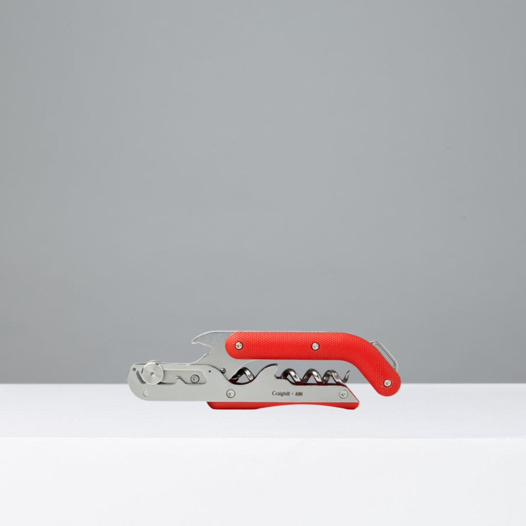 Red corkscrew wine key on a gray background