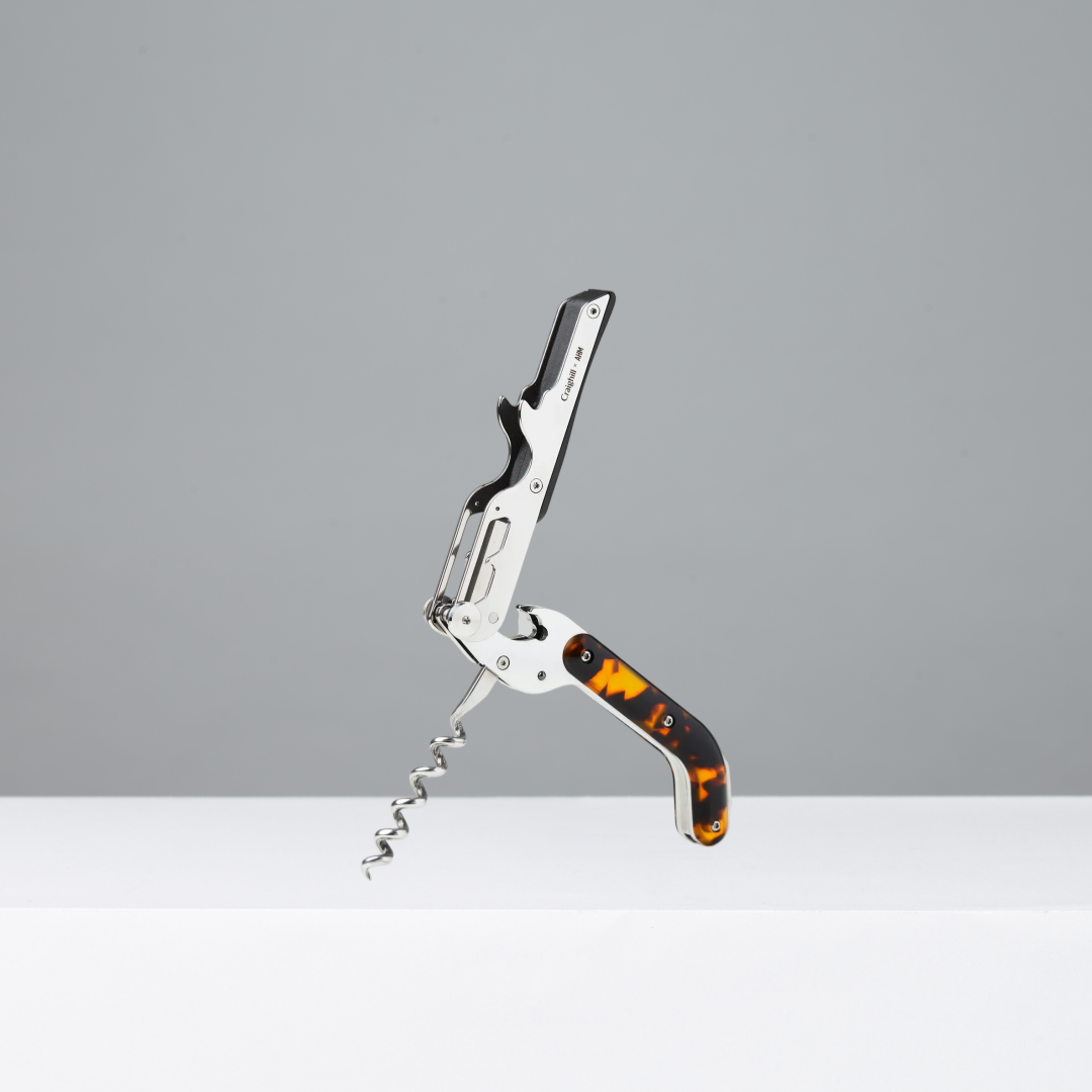 Corkscrew with tortoiseshell handle on a gray background