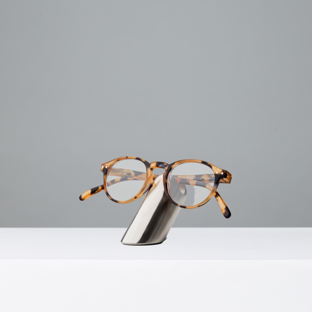 Tortoiseshell sunglasses on a stainless steel eyewear stand