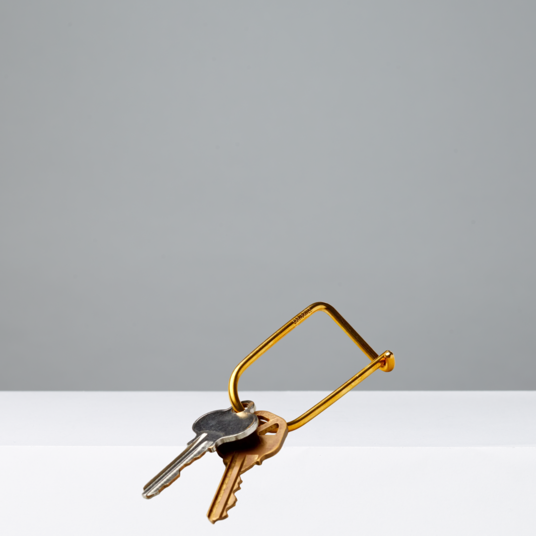 Gold keyring with keys on a gradient gray background