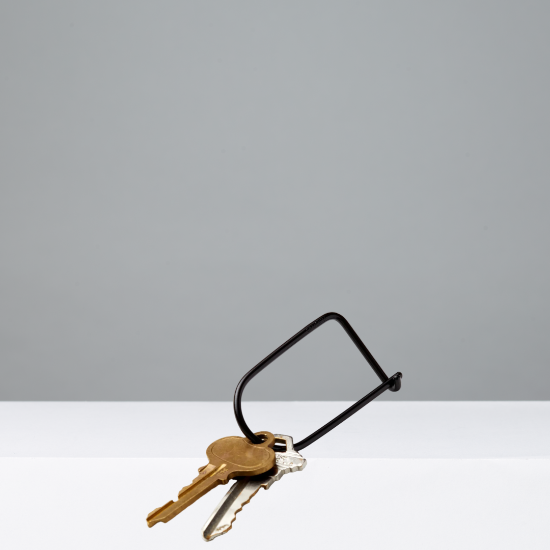 Black keyring with two keys on a gray background