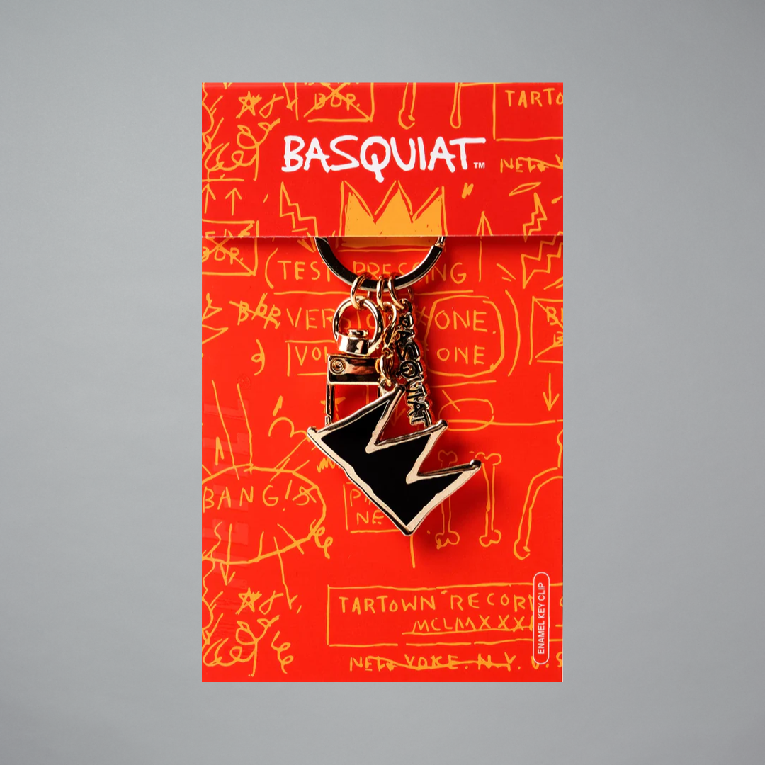 Jean-Michel Basquiat black and gold crown pin on Basquiat branded packaging with red background and white text