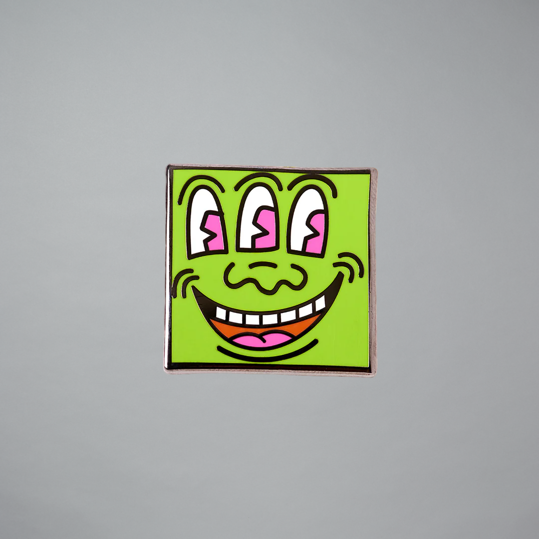 Keith Haring Three Eyed Monster pin on a gray background
