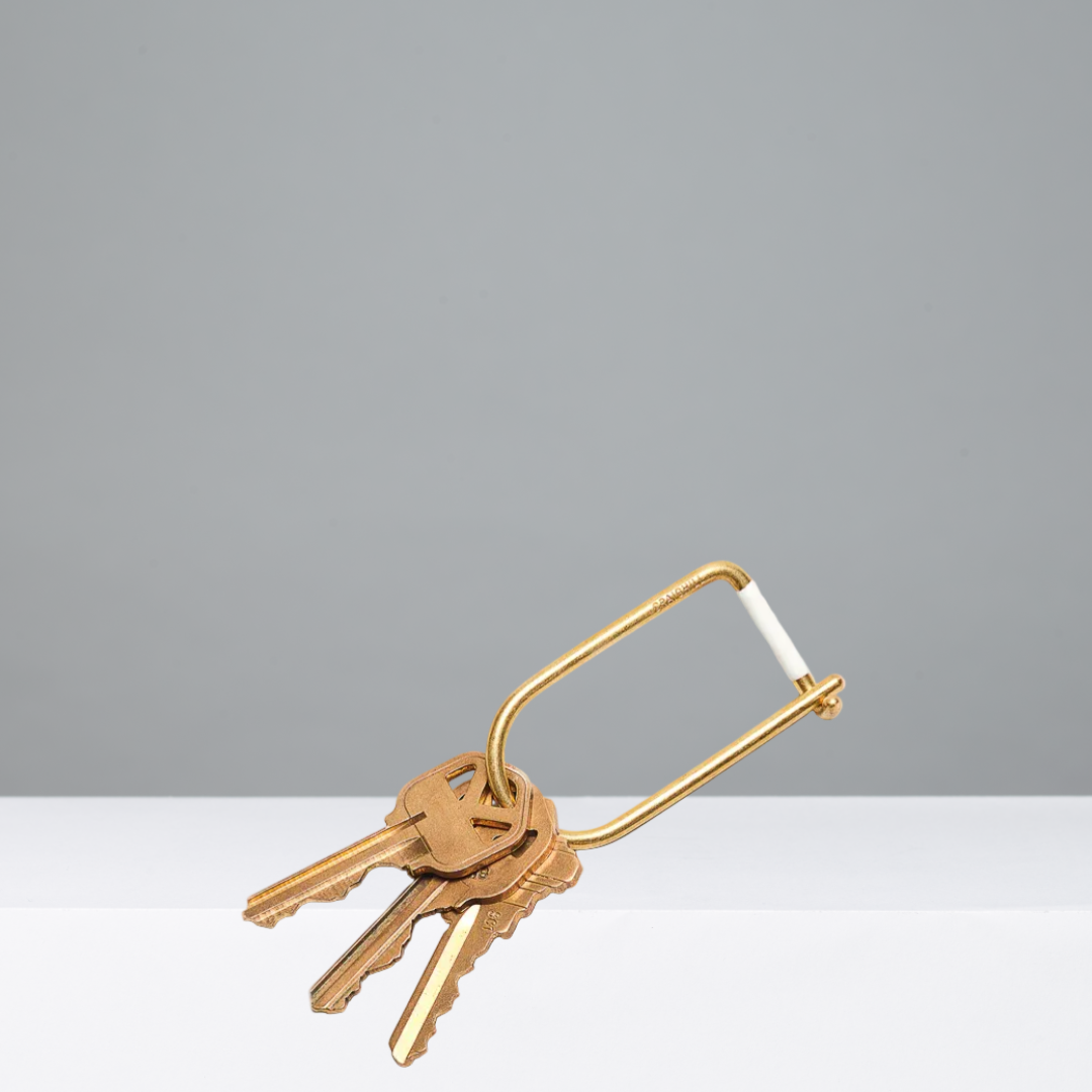 Gold keyring with keys on a gray background