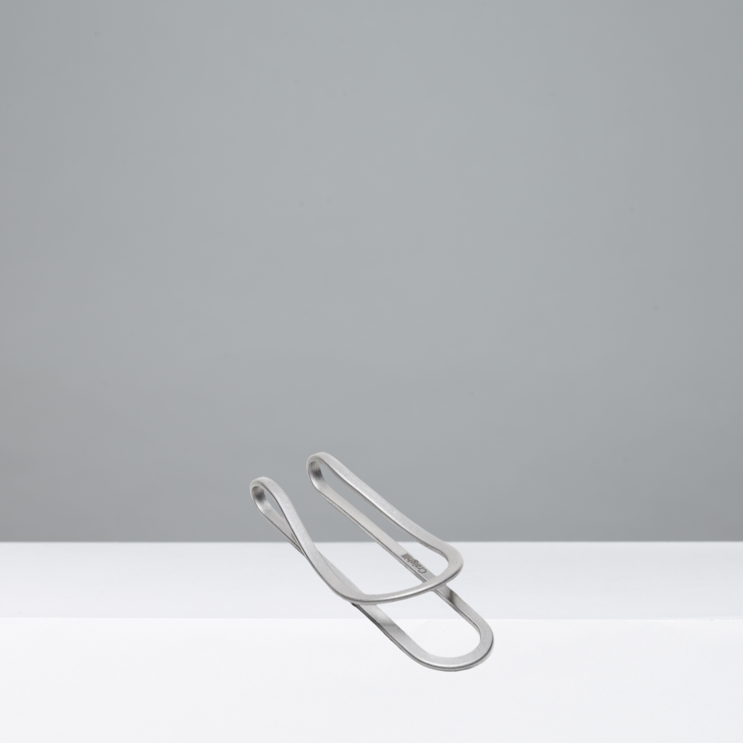 Silver money clip on a gray background