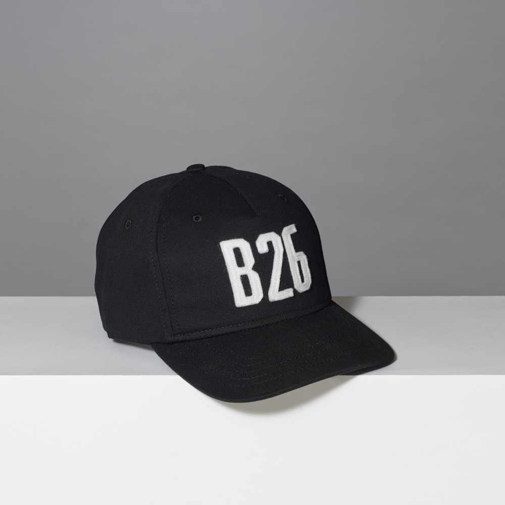 A black baseball cap with 'B26' embroidered in white block letters on the front, set against a neutral gray background.