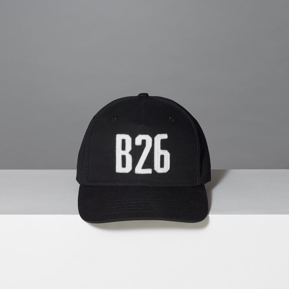 A black baseball cap with 'B26' embroidered in white block letters on the front, set against a neutral gray background.