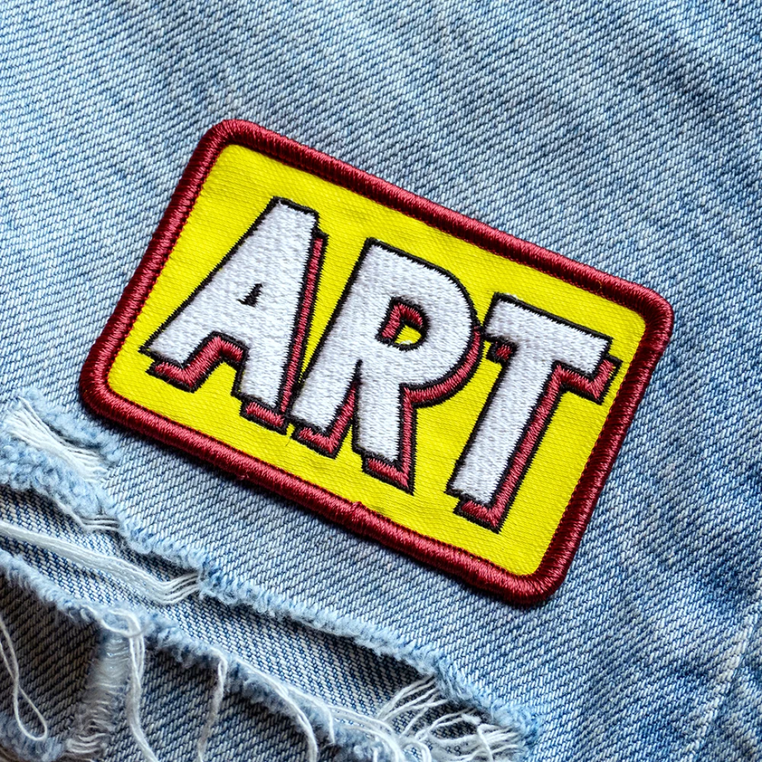 Embroidered patch featuring ART by Roy Lichtenstein ironed onto a pair of denim jeans