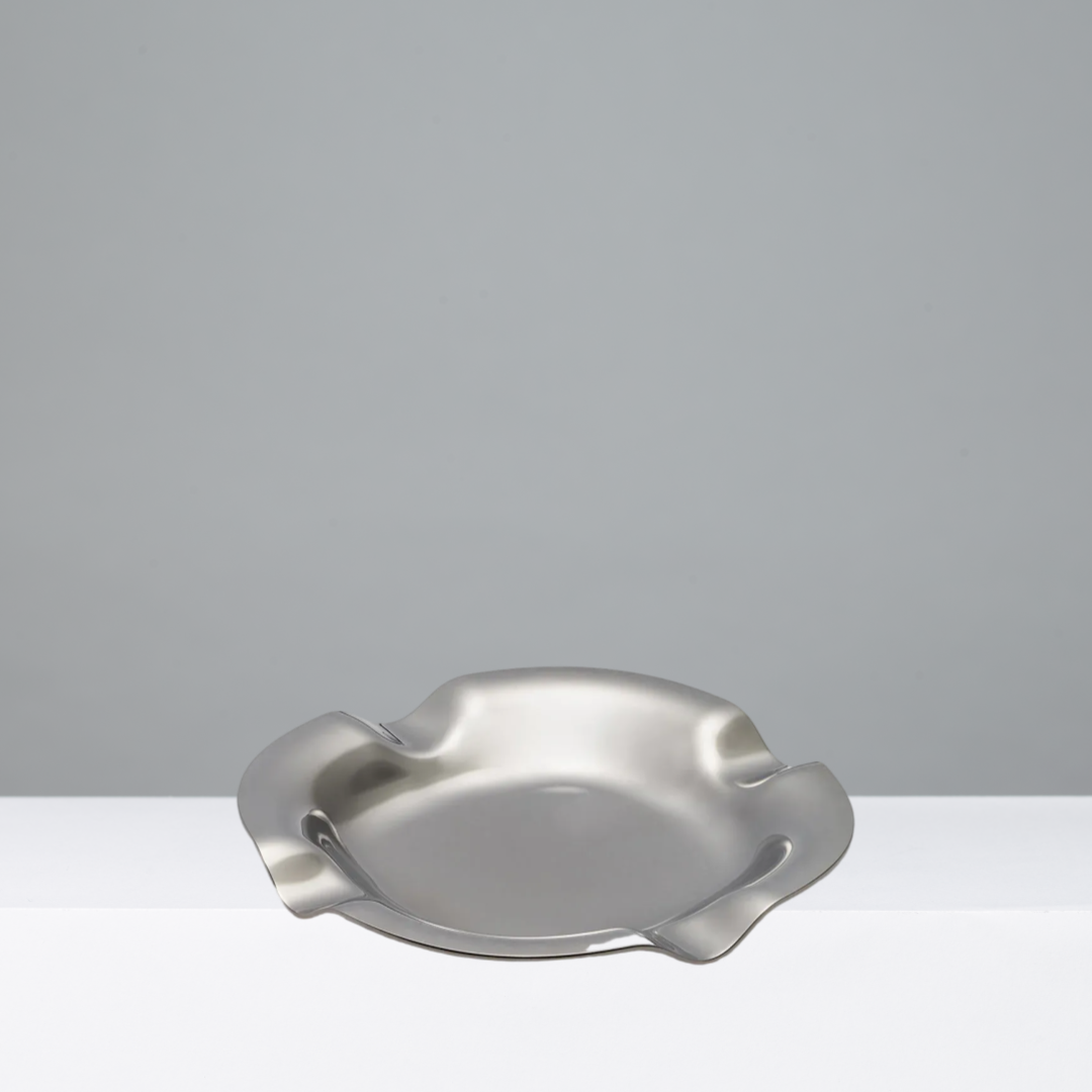 Decorative stainless steel tray on a gray background