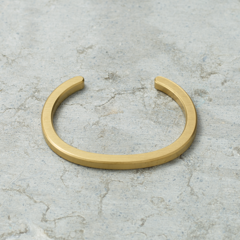 Gold bracelet on a textured gray surface