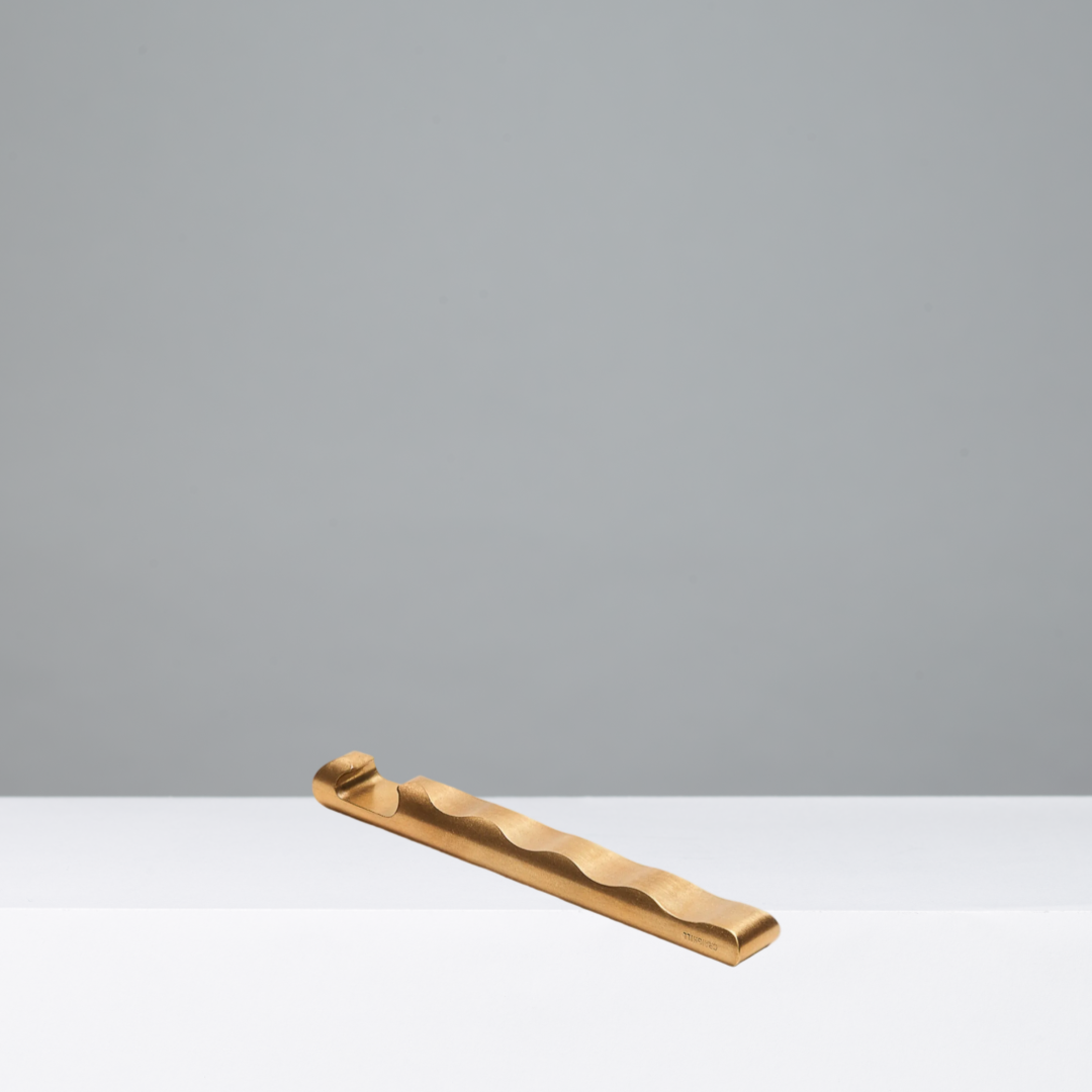 Brass Ripple Opener on a gray background