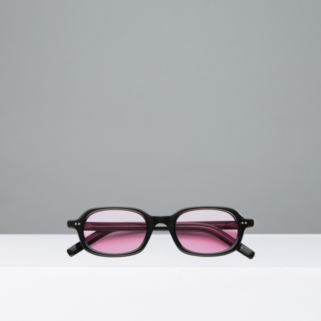 Black sunglasses with pink lenses on a gray background