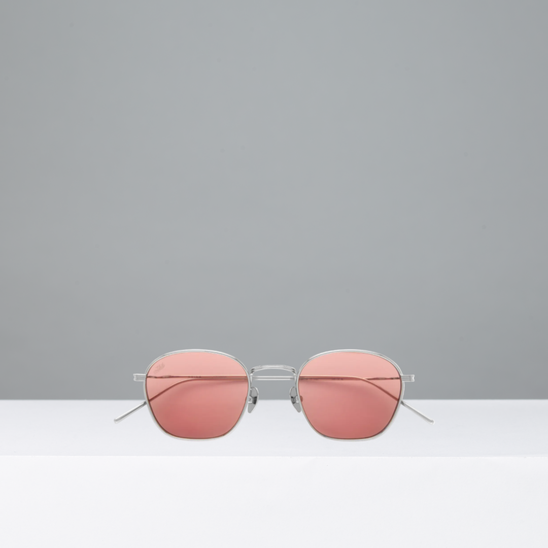 Pink sunglasses with silver frames on a gray background