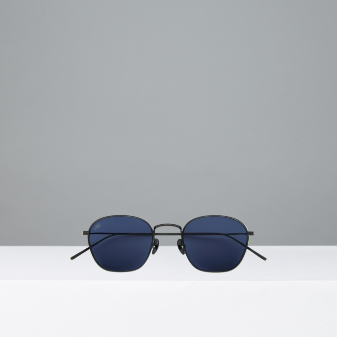 Sunglasses with blue lenses and black frames on a gray background