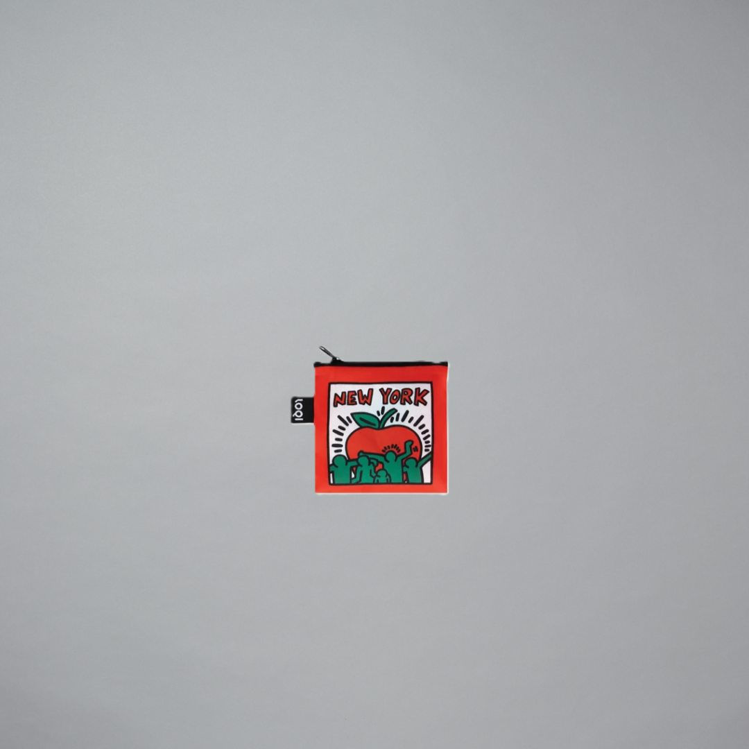 A red pouch with a New York themed artwork by Keith Haring on a gray background
