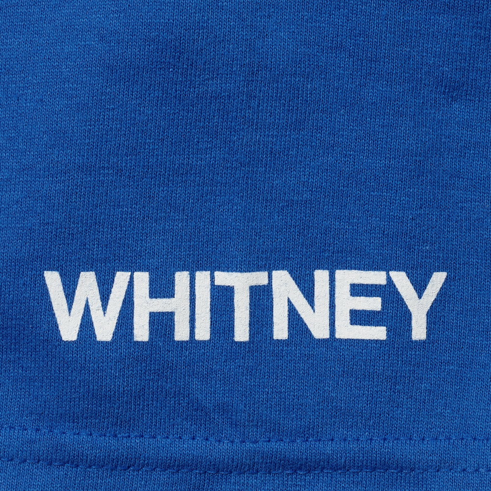 Whitney in white screen printed onto the sleeve of a blue t-shirt