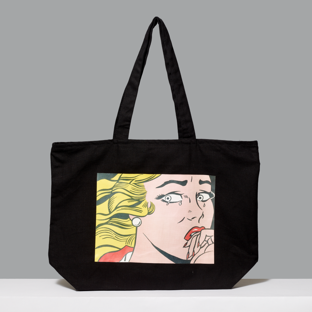 Black 100% cotton tote bag featuring Roy Lichtenstein's Crying Girl against a gray background