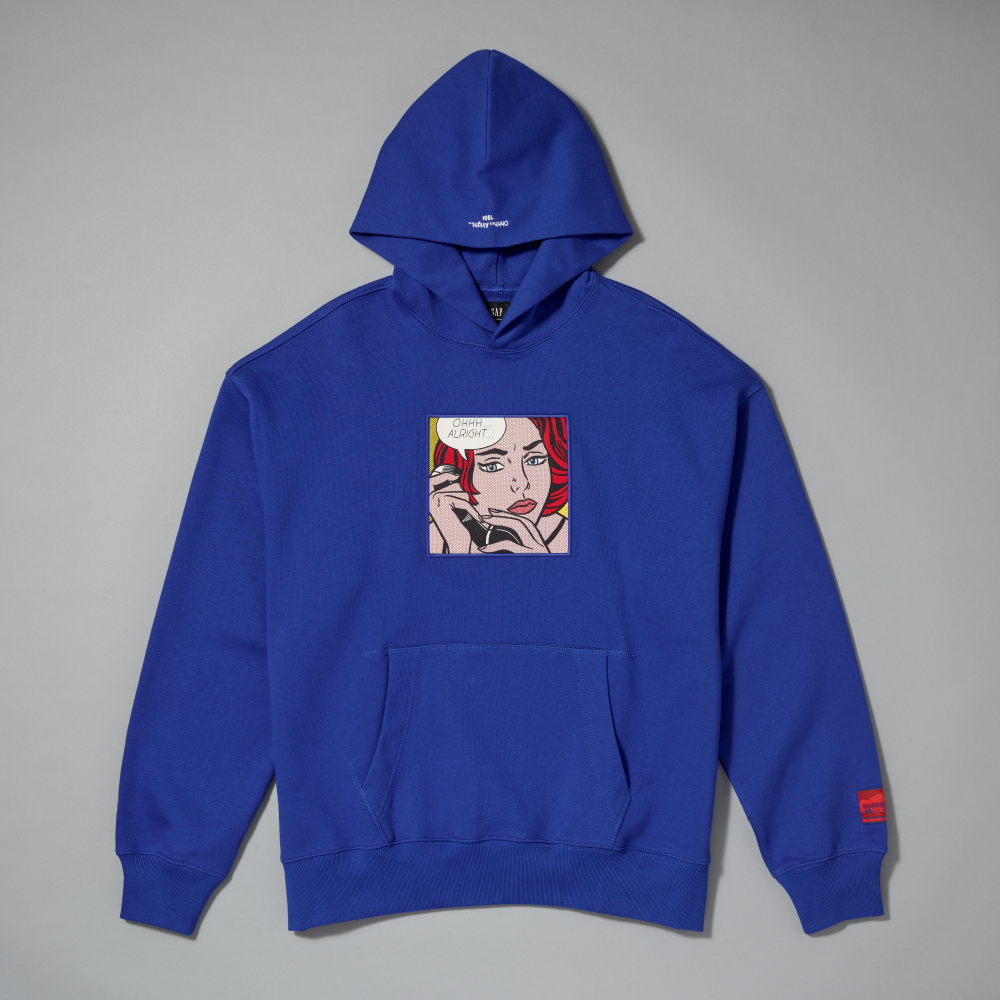 A royal blue pullover hoodie with a graphic print inspired by Roy Lichtenstein's work Ohhh... Alright... on the chest, with a kangaroo pocket and ribbed cuffs and hem, laid flat on a neutral gray background