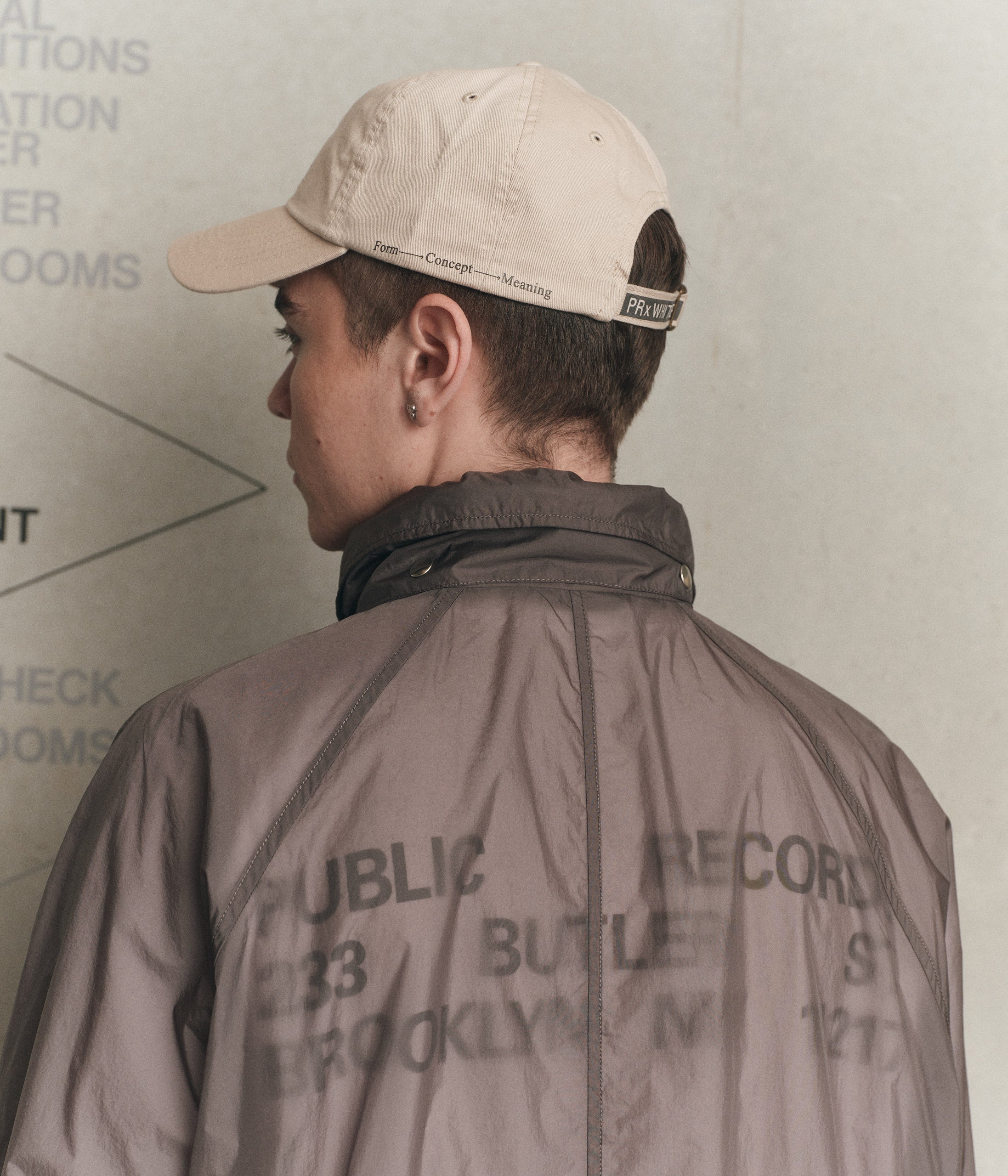 Model wearing 100% cotton beige cap with the Public Records logo in black