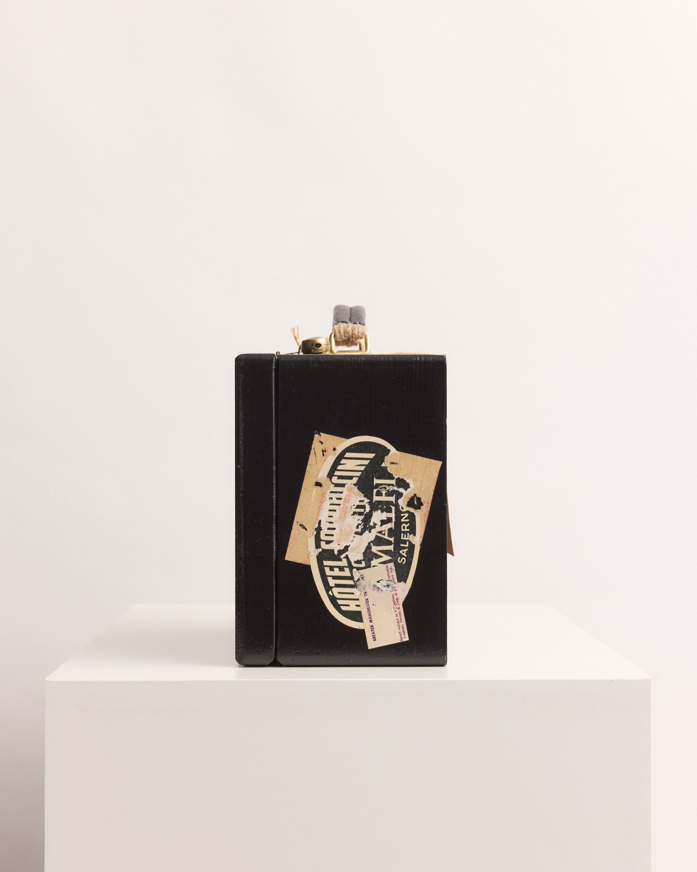 Black suitcase box with decorative label on a white background