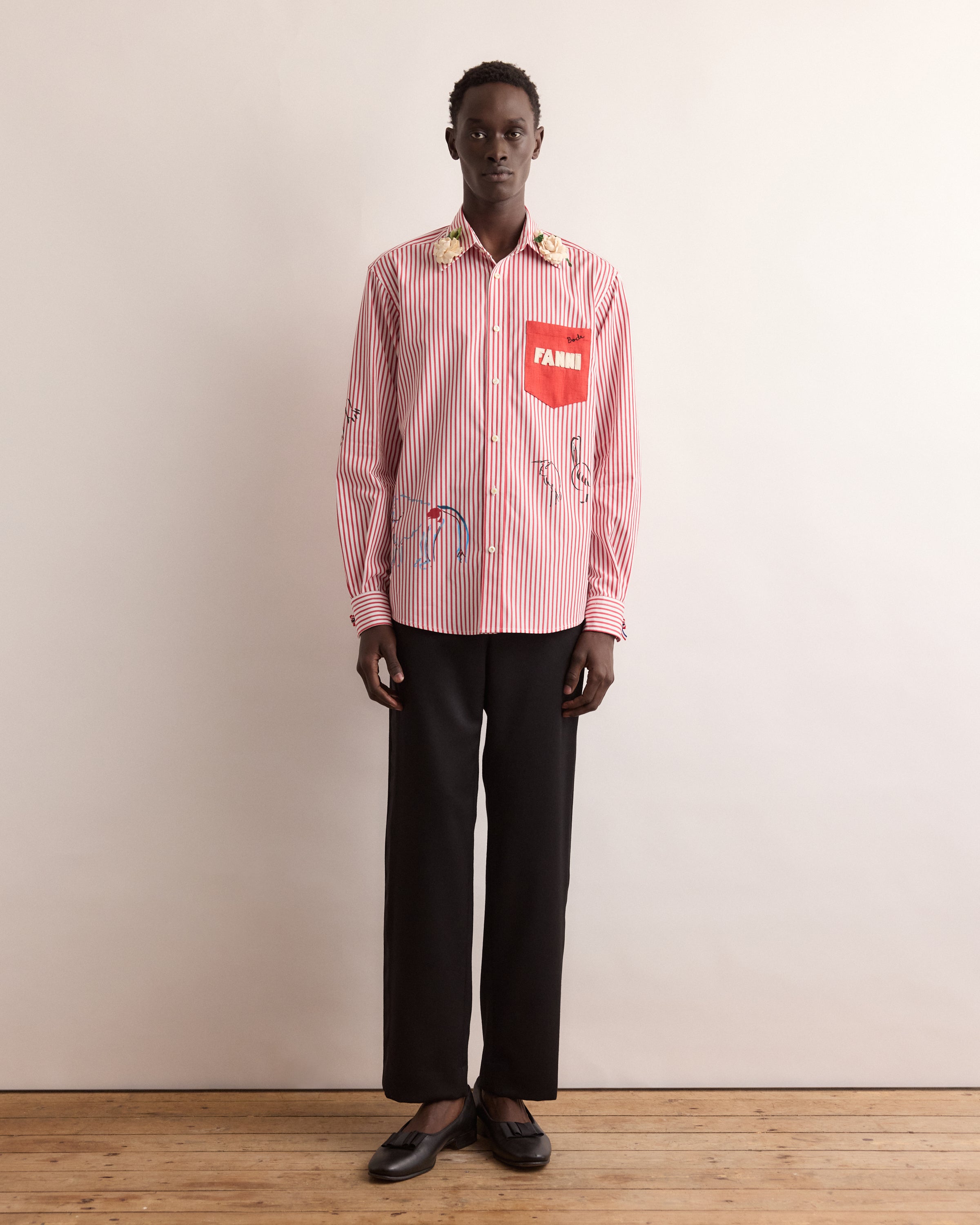 Person wearing a red and white striped shirt with a brand logo on a beige background