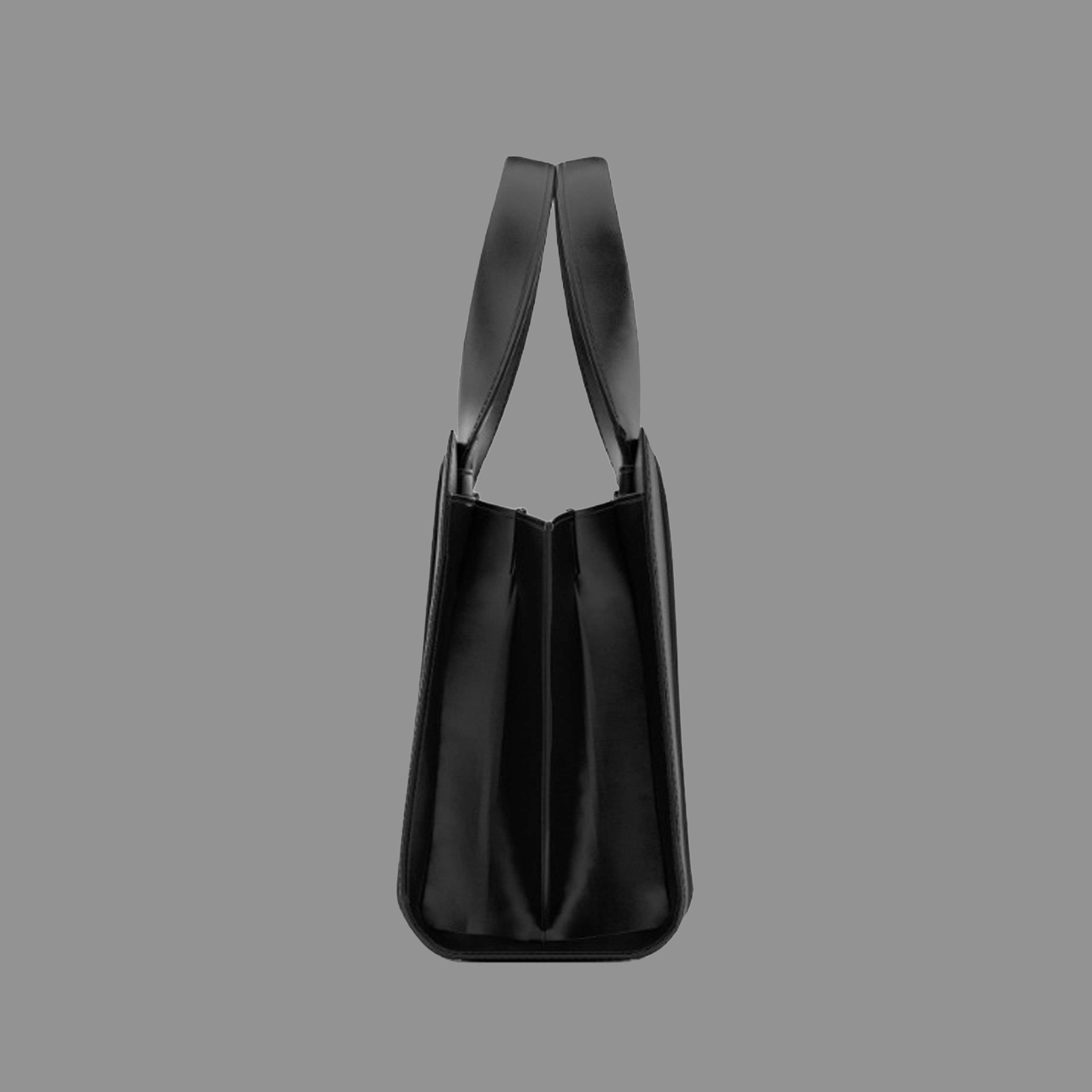 Side view of a black leather handbag with thin straps on a gray background